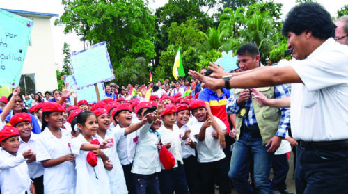 Niños vestidos como Hugo Chávez, levantan el puño y le cantan a Evo Morales